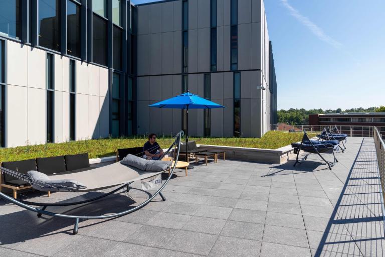 The rooftop terrace of the Learning Commons offers a serene outdoor space for studying and relaxation, featuring hammocks and shaded seating.